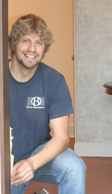 Deon Brugmann, lead carpenter at Jax Woodworks, sitting in a doorway on a job.