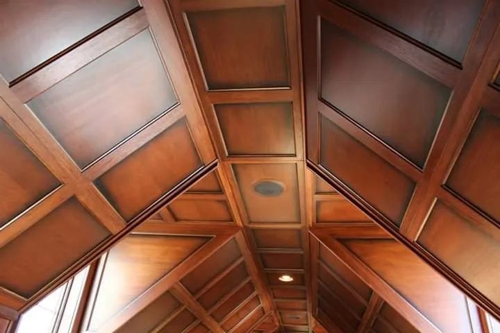 A coffered wooden ceiling meeting at a ridge, panel by panel.